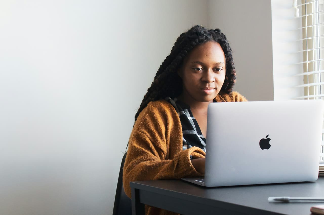A woman working at a laptop at a table
