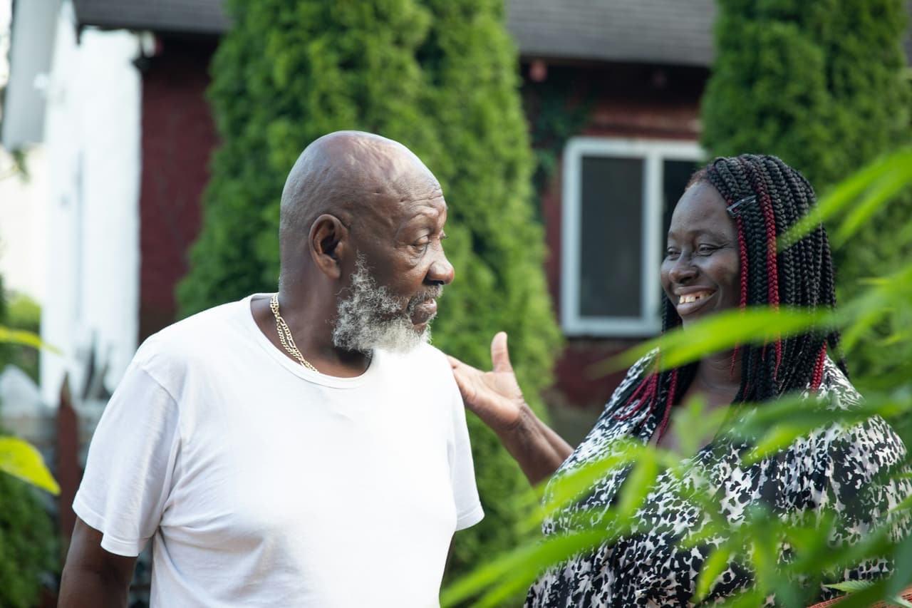An older man and woman talking outdoors