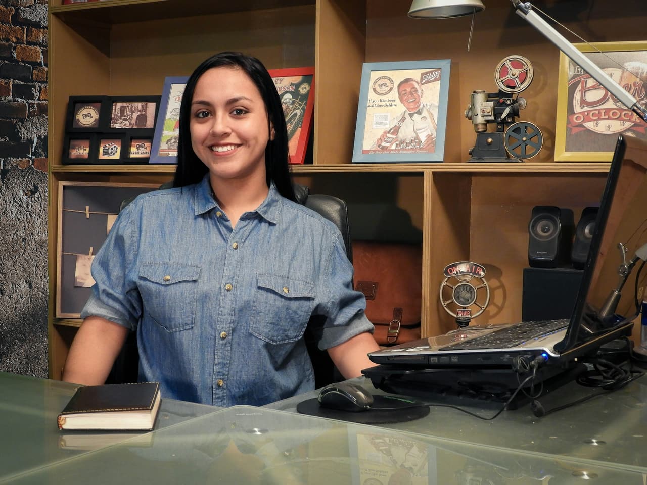 A Latina business owner smiling at her desk in her office